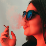 11Woman smoking a joint with a red hue over the photo.